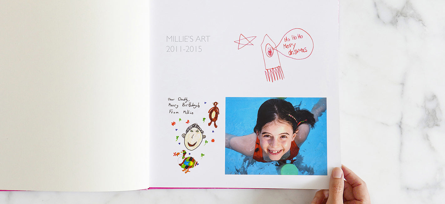 First page of a keepsake kids' art book showing the title Millie's Art 2011-2015 with drawings by the child saying Merry Christmas and Merry Birthday