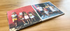 An open layflat photo book showing two colourful photos of a family on holiday somewhere warm