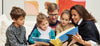A family with young children gather round an open kids' art book