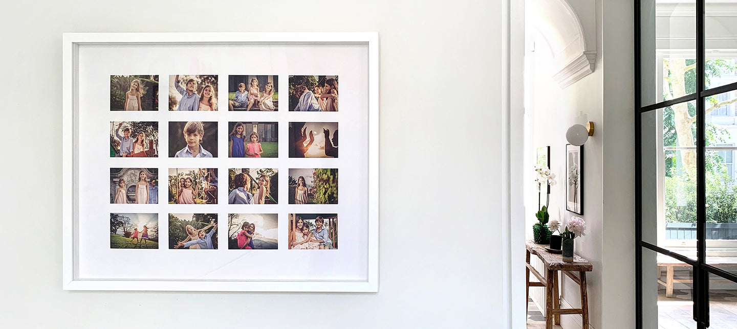 A framed photo collage  with multiple family photographs arranged in a grid pattern hanging on the wall of a nicely decorated house.